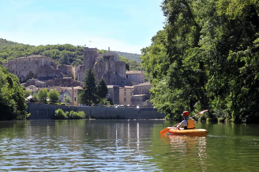 Kayak devant un village médiéval au bord de l'eau.