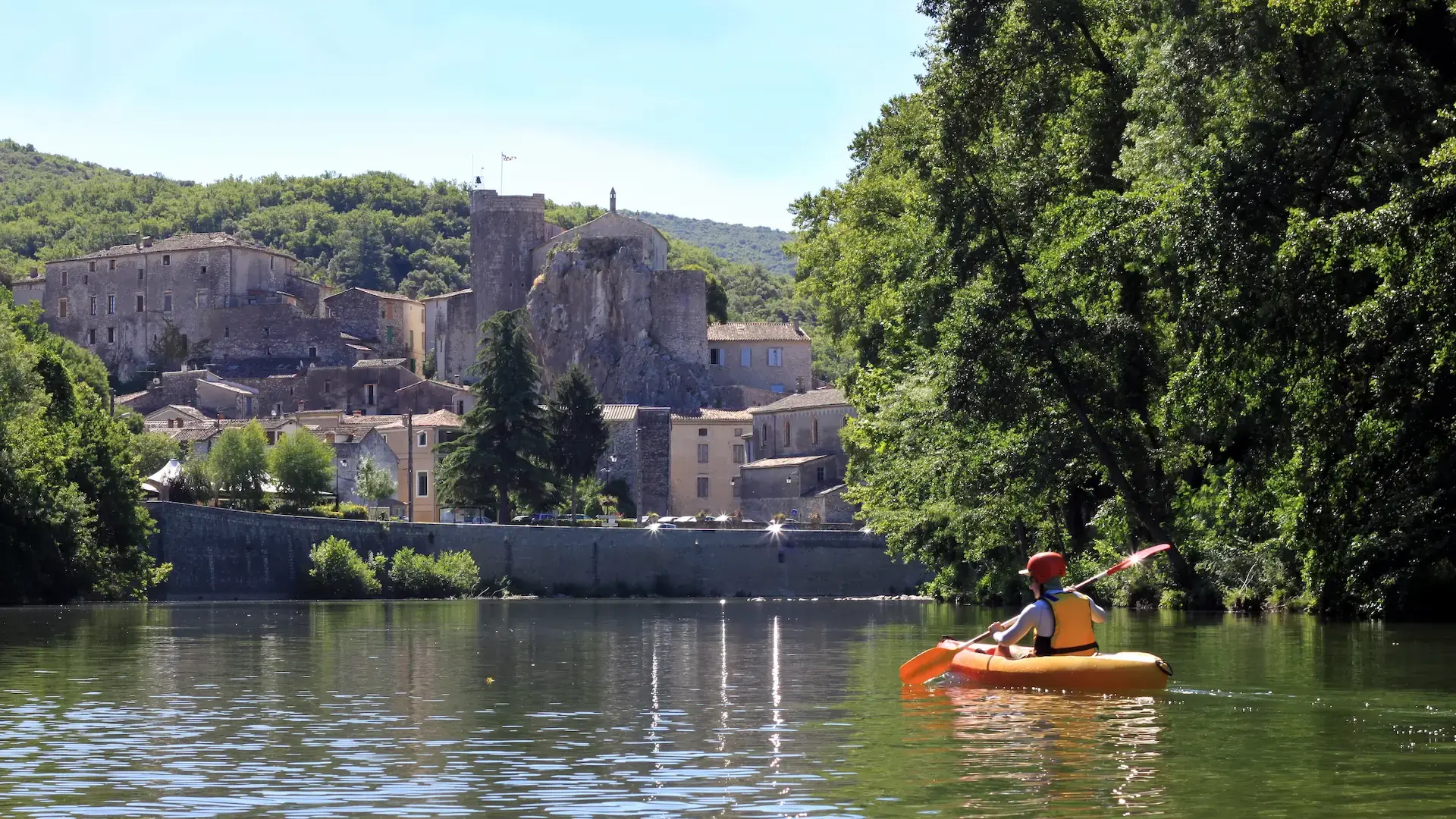 Kayak devant un village médiéval au bord de l'eau.
