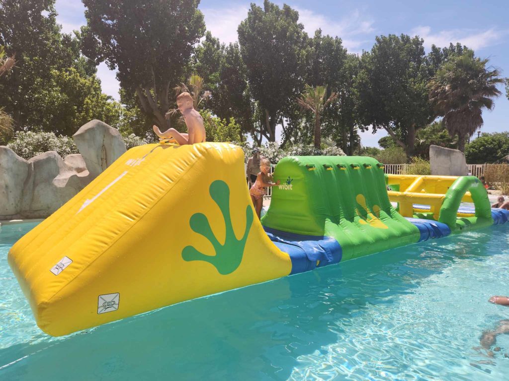 Enfants jouant sur structure gonflable aquatique.