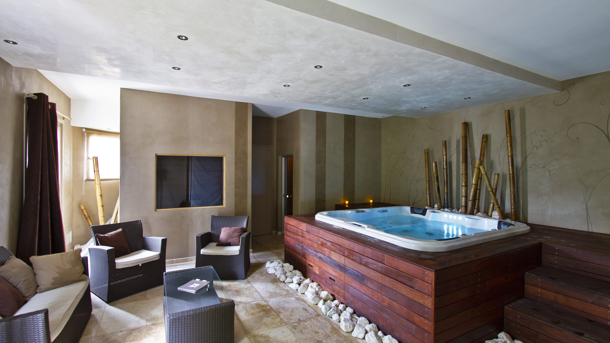 Jacuzzi intérieur avec fauteuils et décor bambou