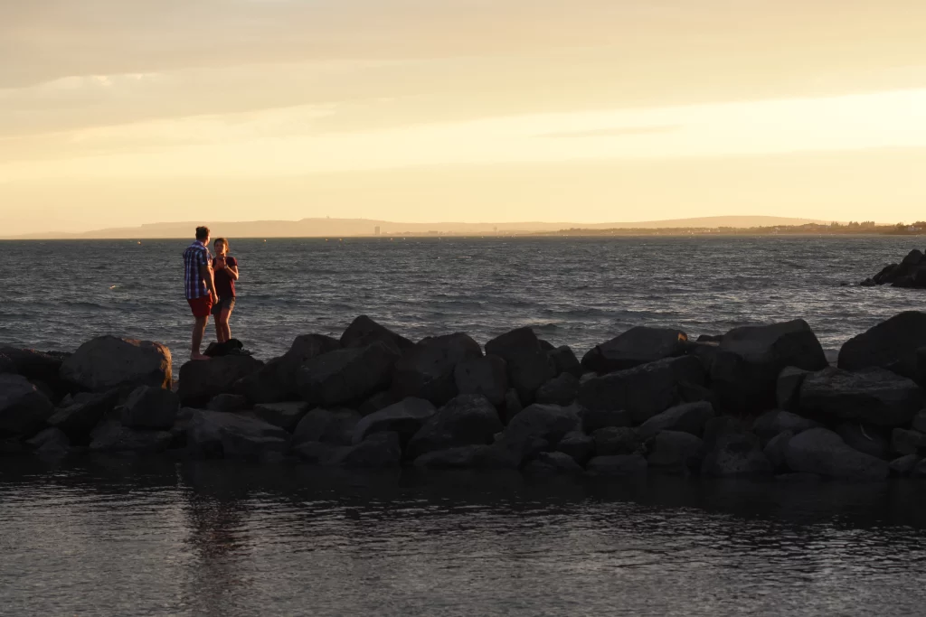 Couple sur rochers au coucher du soleil