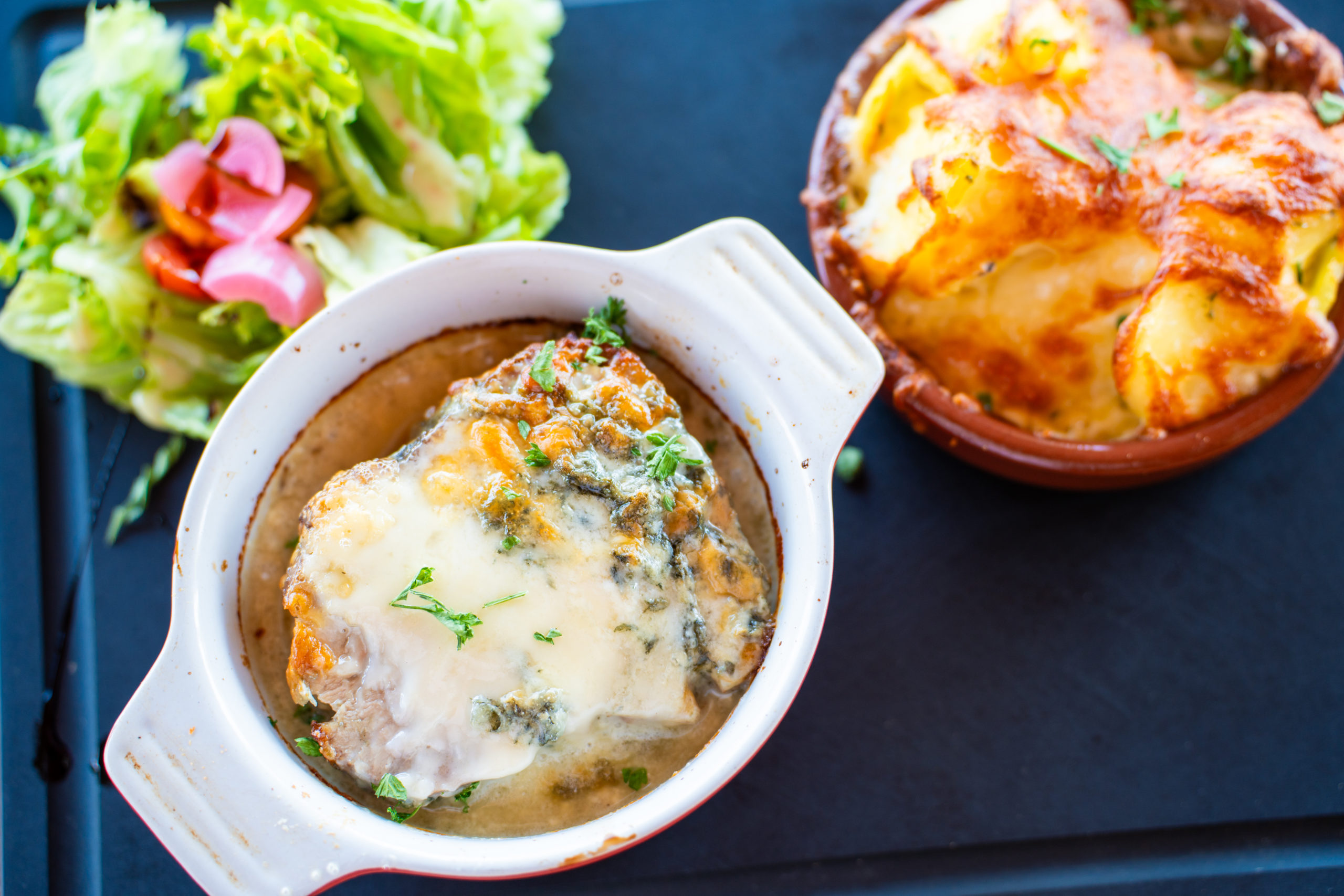 Plat fromages gratinés et salade verte.
