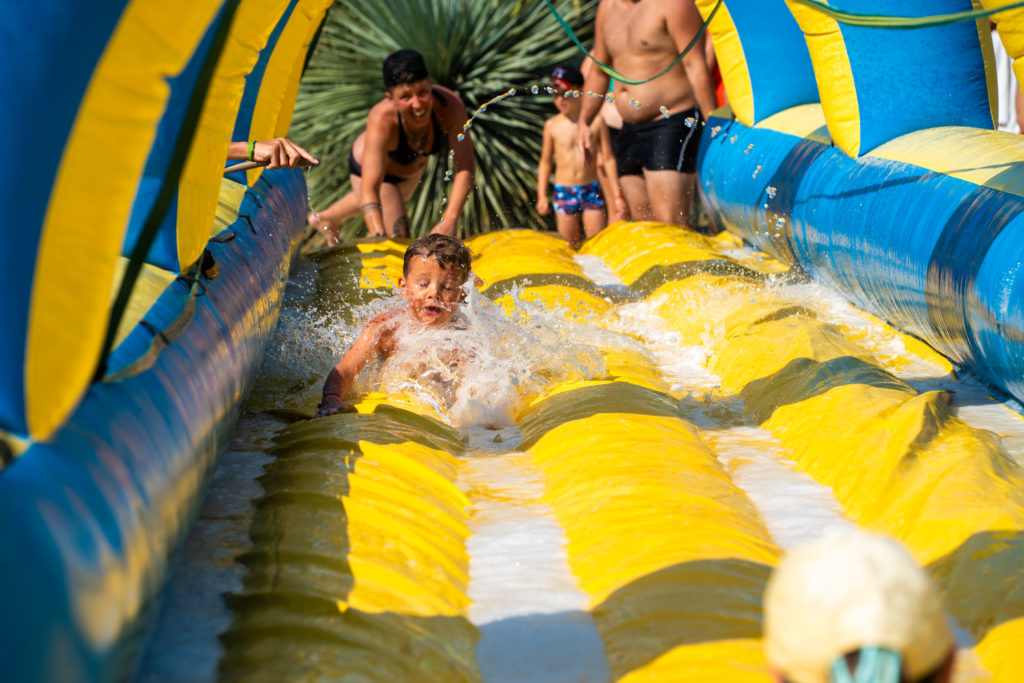 Enfant glissant sur un toboggan aquatique gonflable.