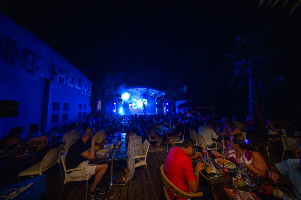 Groupes de personnes dînant lors d'un spectacle nocturne.