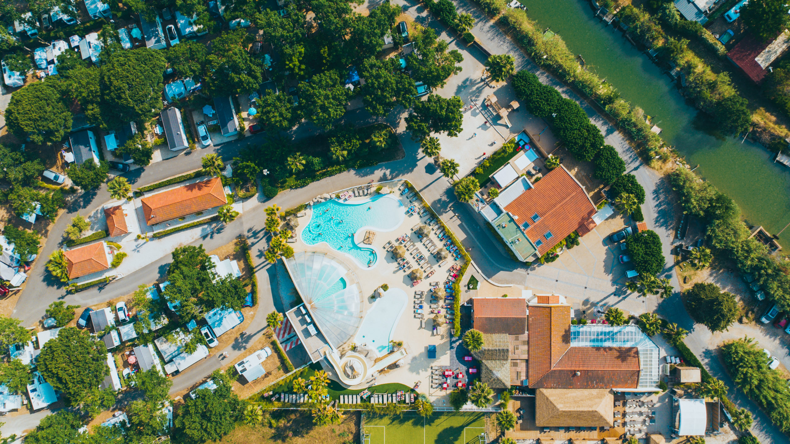 Vue aérienne d'un complexe avec piscine et verdure.