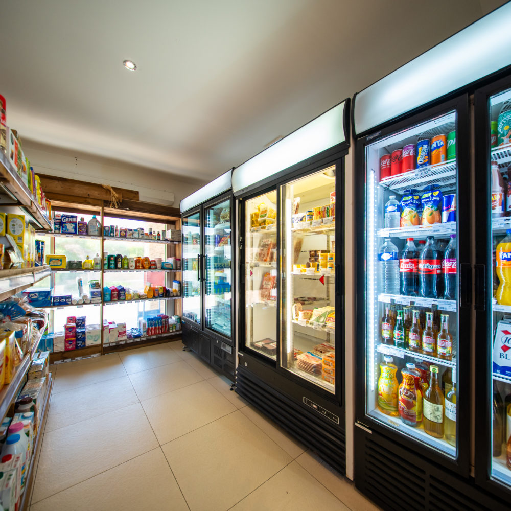 Épicerie avec rayons et réfrigérateurs.