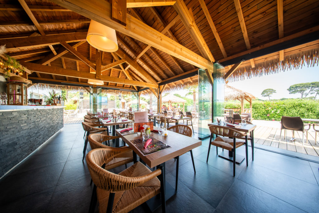 Intérieur d'un restaurant avec terrasse ensoleillée.