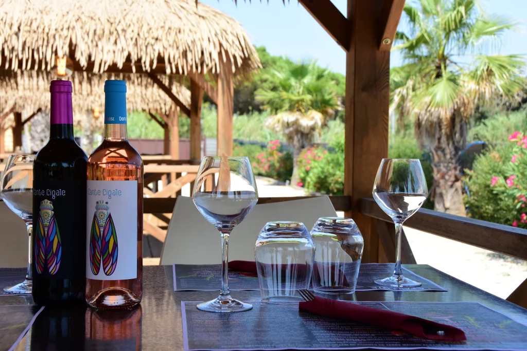 Bouteilles de vin sur une table extérieure tropicale.