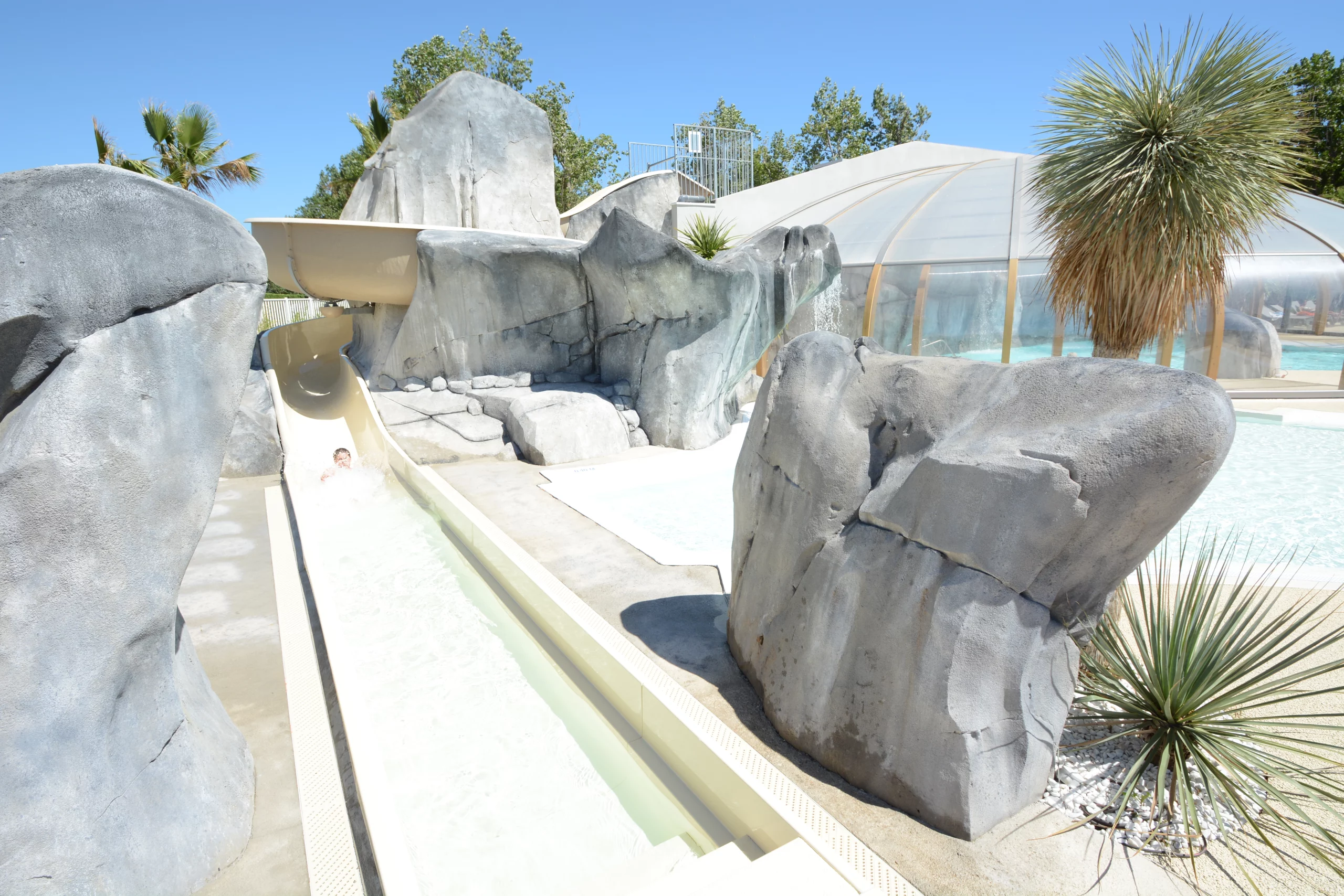 Toboggan aquatique, rochers et piscine couverte.