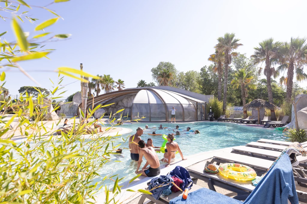Piscine extérieure avec des personnes et palmiers