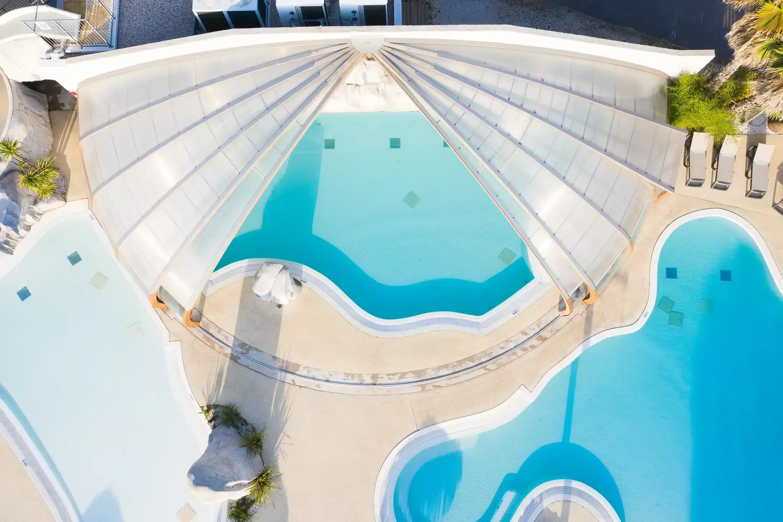Vue aérienne de piscines modernes avec toit rétractable.