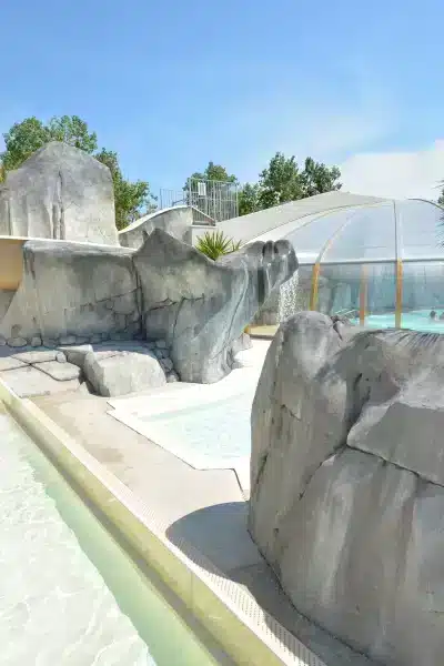 Piscine avec toboggan et dôme couvert.