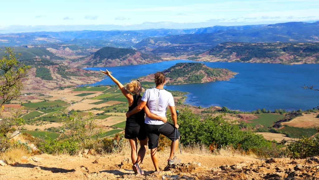 Couple devant un paysage de lac et montagnes.