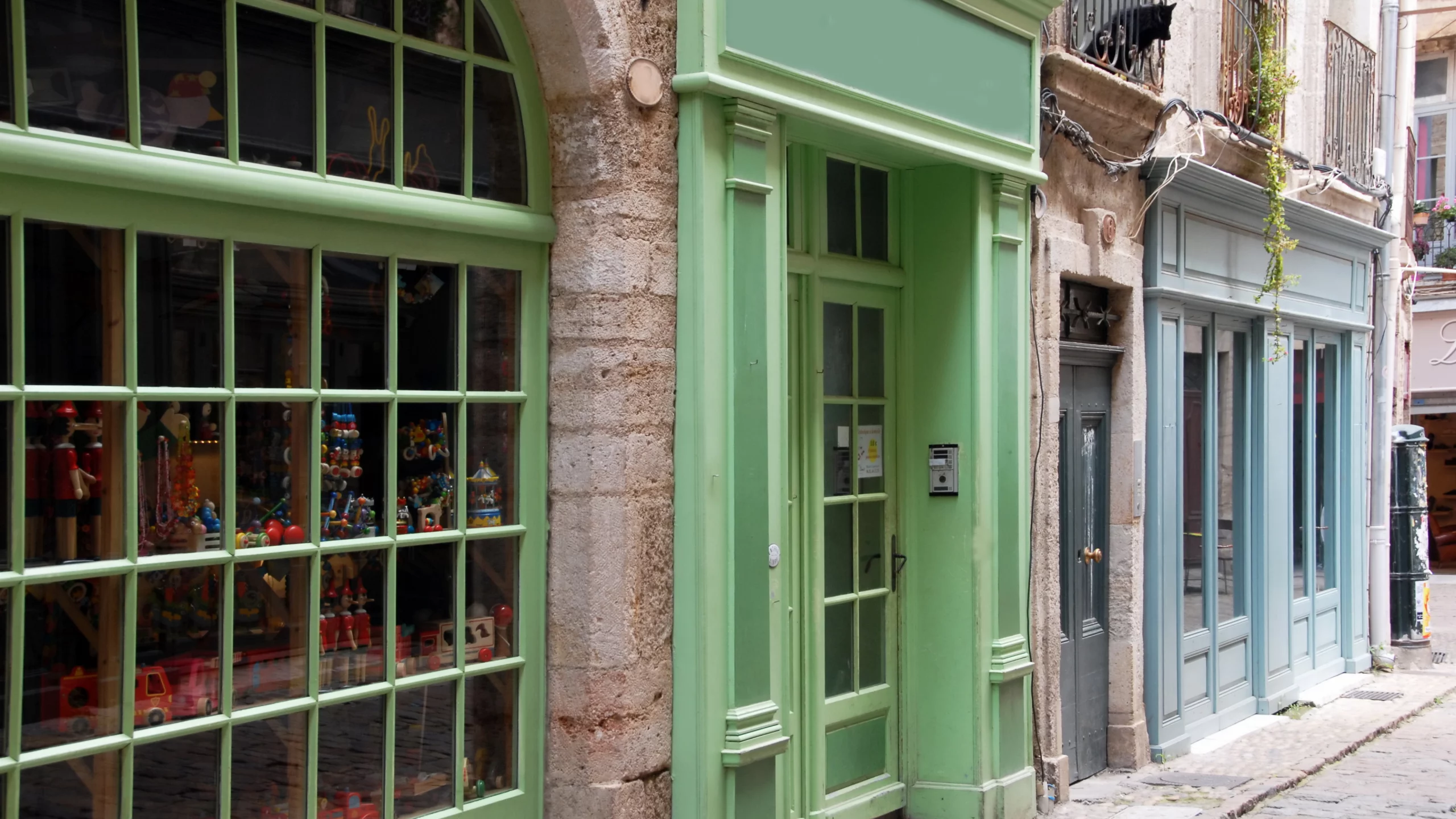 Rue avec boutiques colorées et étroites.