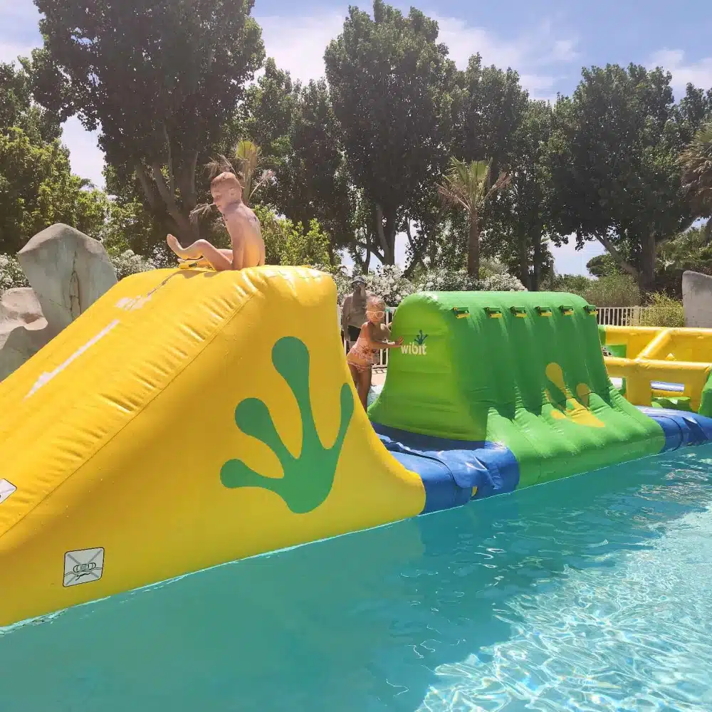 Enfants jouent sur structure gonflable aquatique.