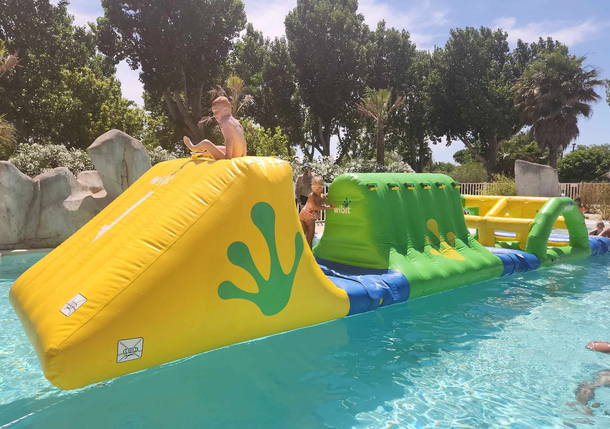 Enfants jouent sur structure gonflable aquatique.