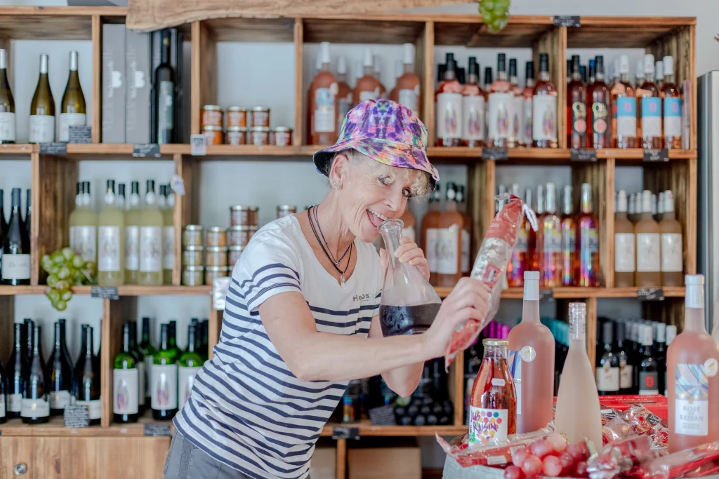 Femme déguste produit local dans cave à vin.