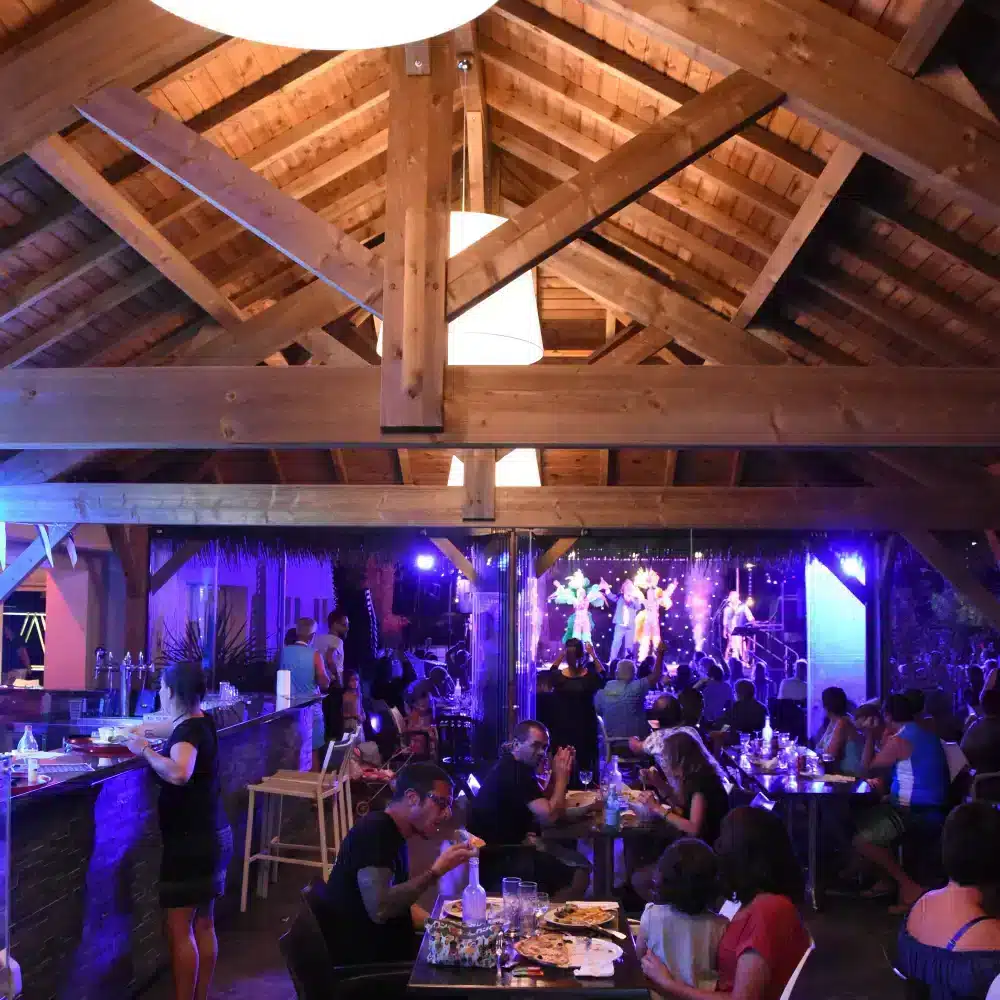 Restaurant bondé avec spectacle et lumière bleue.