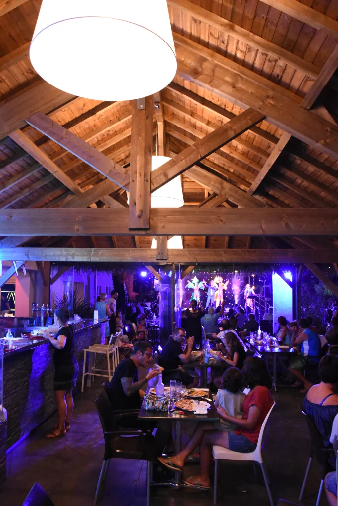 Restaurant bondé avec spectacle et lumière bleue.