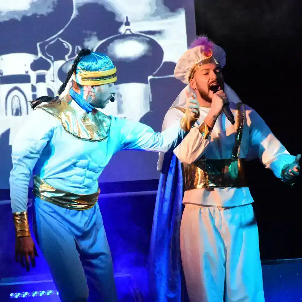 Deux hommes en costumes orientaux chantent sur scène.