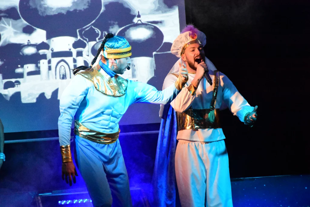 Deux hommes en costumes orientaux chantent sur scène.