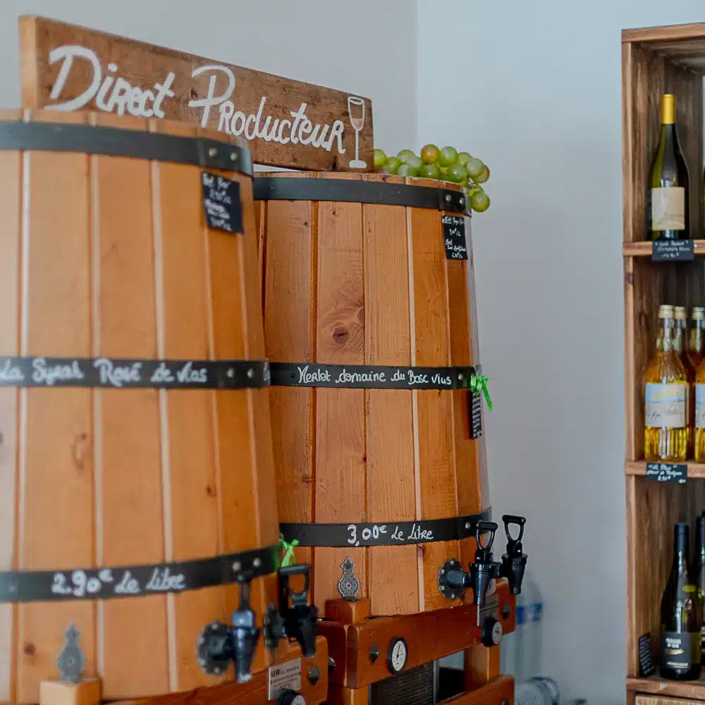 Tonneaux et bouteilles de vin dans une cave.