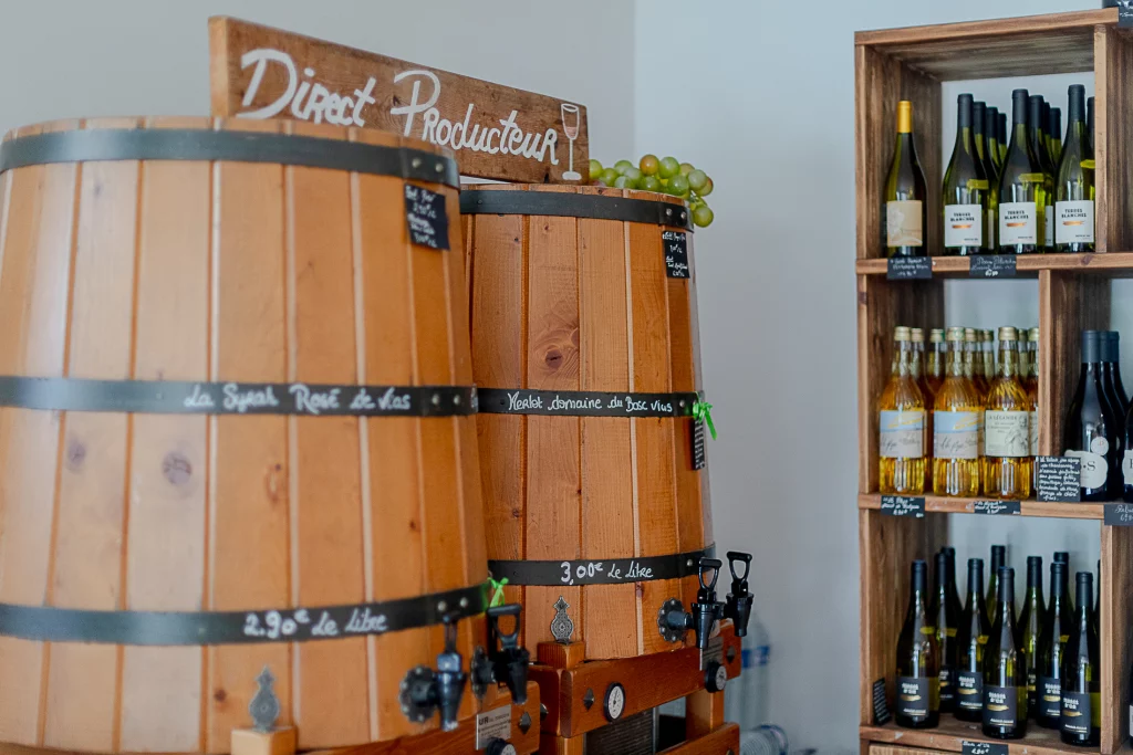 Tonneaux et bouteilles de vin dans une cave.