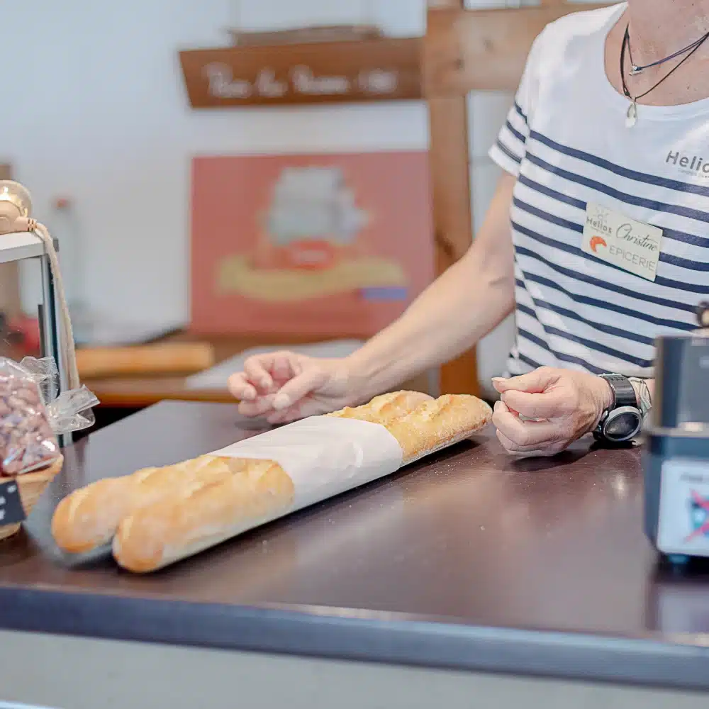 Épicière avec baguettes sur le comptoir.