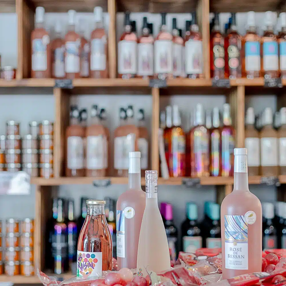 Bouteilles de vin sur tonneau avec raisins rouges.