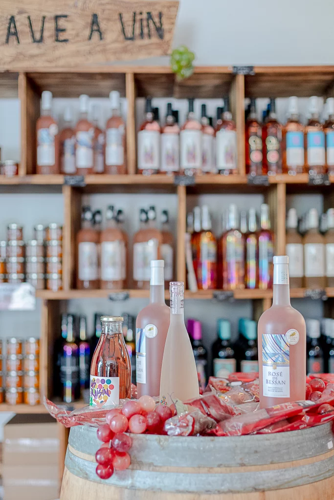 Bouteilles de vin sur tonneau avec raisins rouges.