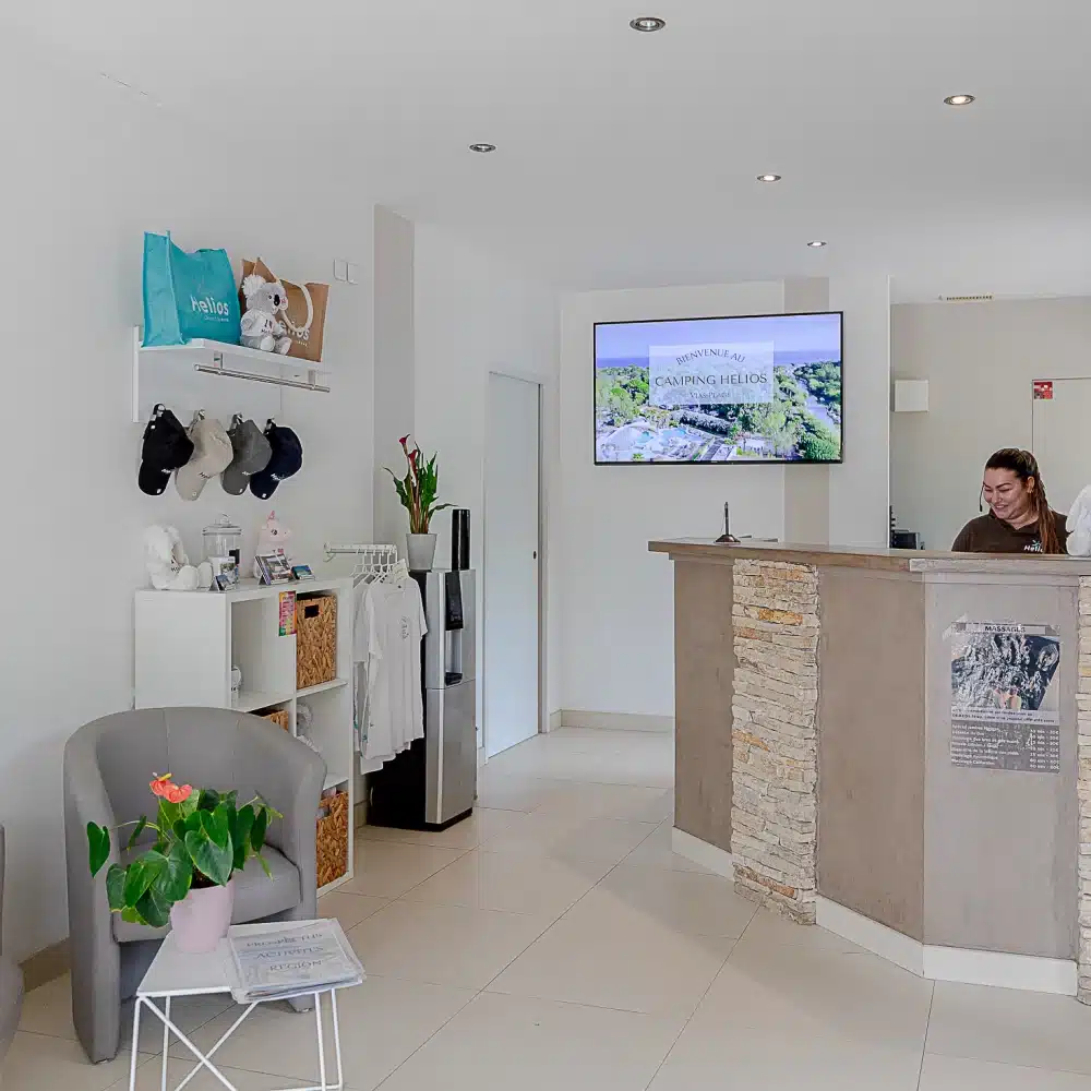 Accueil camping moderne avec réceptionniste souriante.
