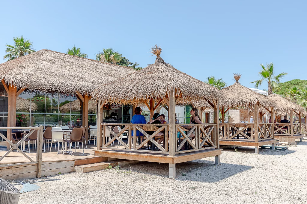 Terrasse extérieure avec paillotes et chaises.