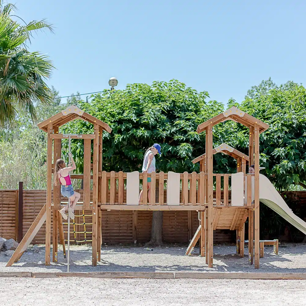 Enfants jouant sur une aire de jeux en bois.