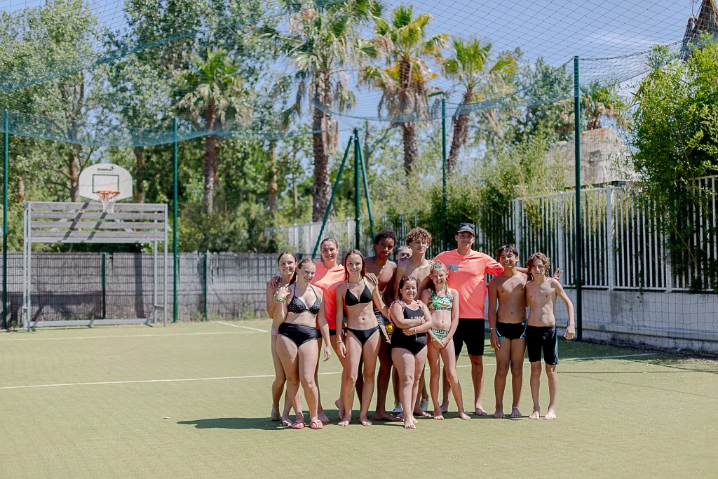 Groupe en maillots sur terrain de sport extérieur.