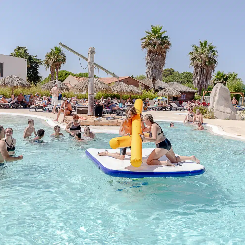 Personnes s'amusant dans une piscine ensoleillée.