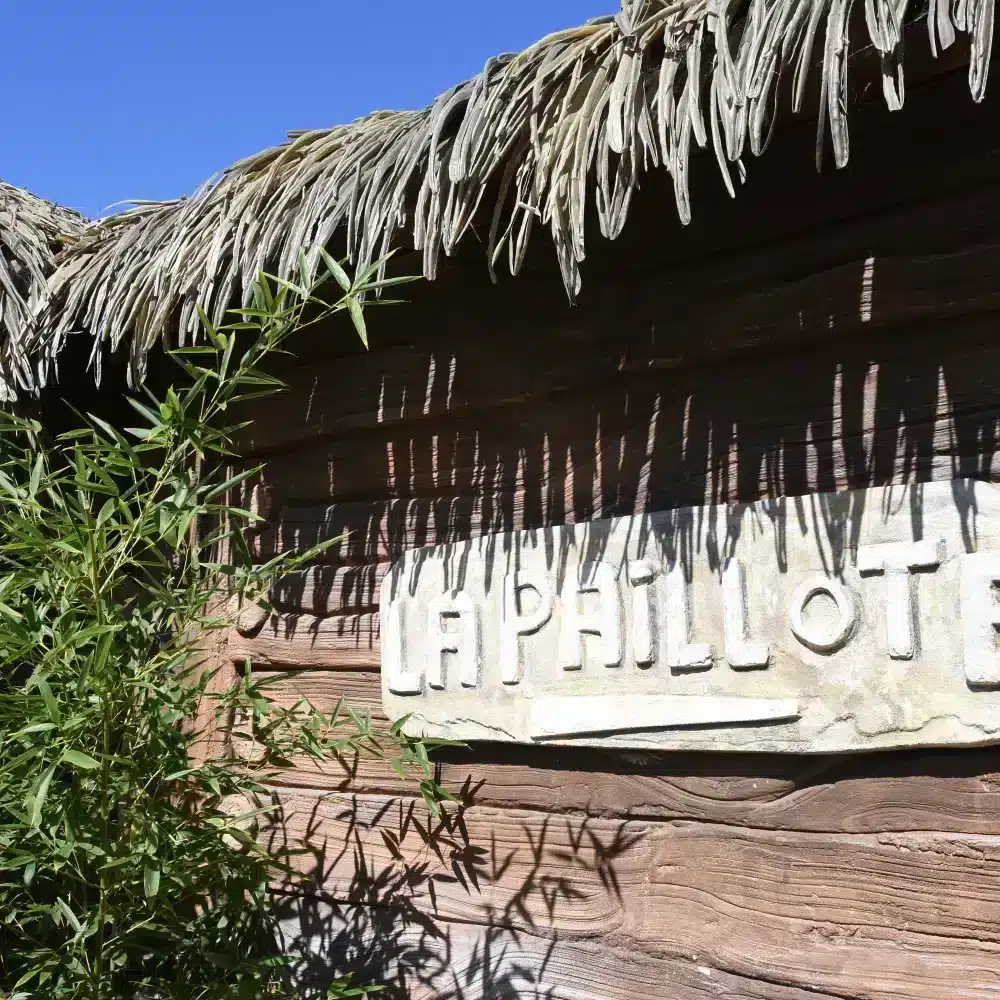 Entrée en bois avec toit de chaume.