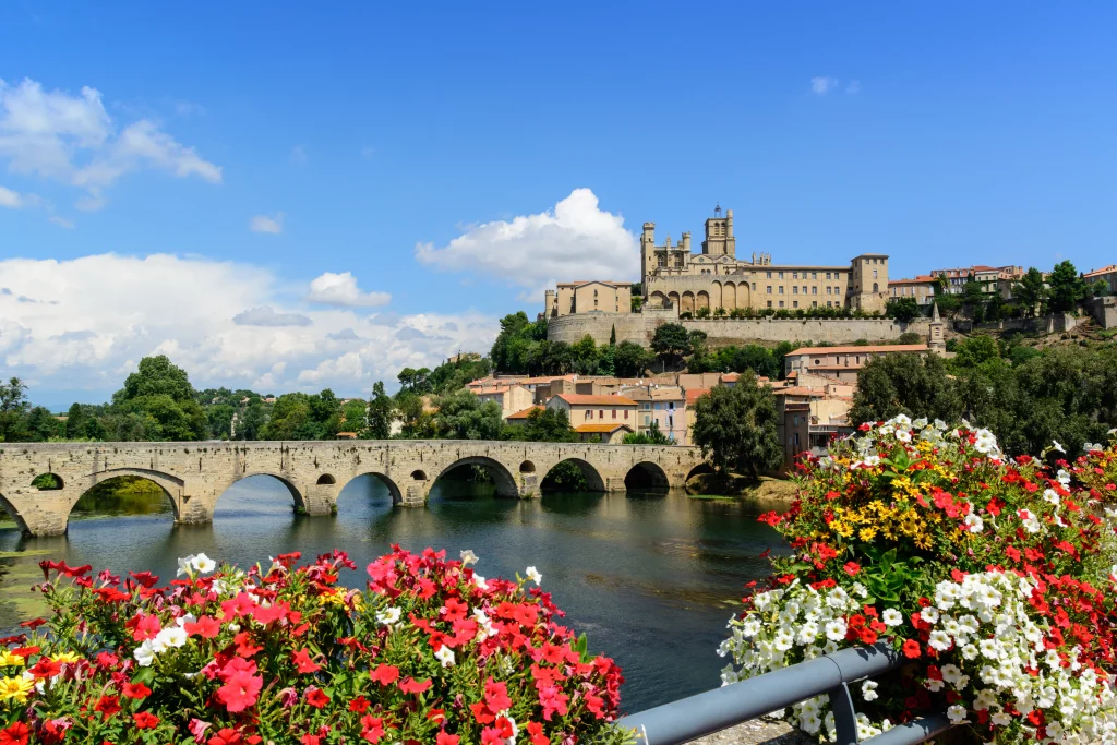 Vue pittoresque de Béziers avec pont fleuri.