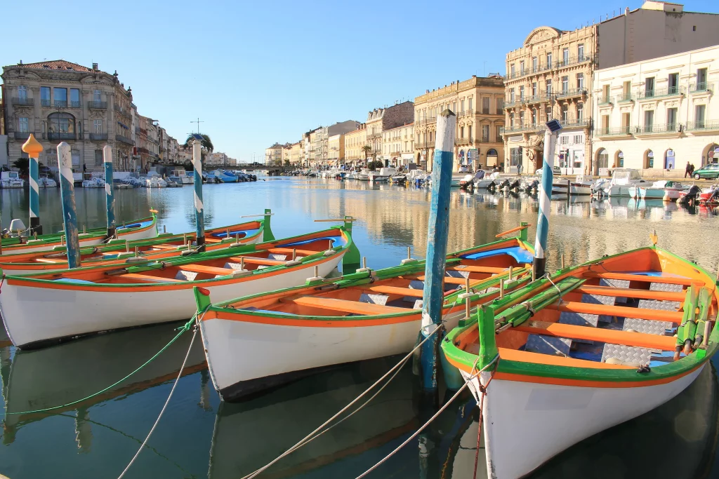 Barques colorées amarrées sur un canal ensoleillé.