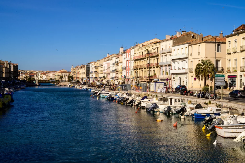 Canal bordé de bâtiments et bateaux.
