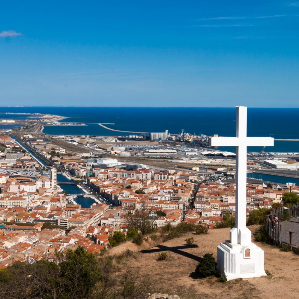 Vue aérienne d'une ville côtière avec croix blanches.