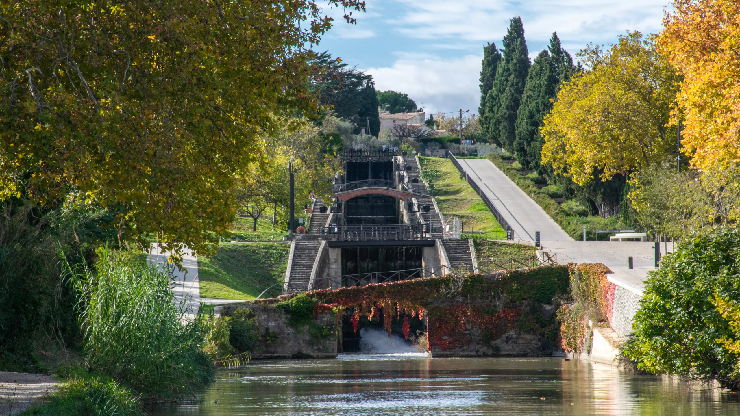 Écluses sous ciel bleu et arbres automnaux.