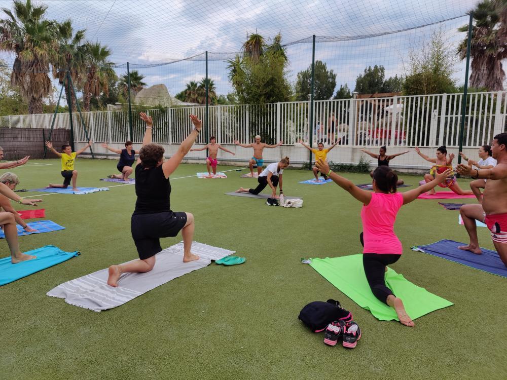 Cours de yoga en plein air sur pelouse.